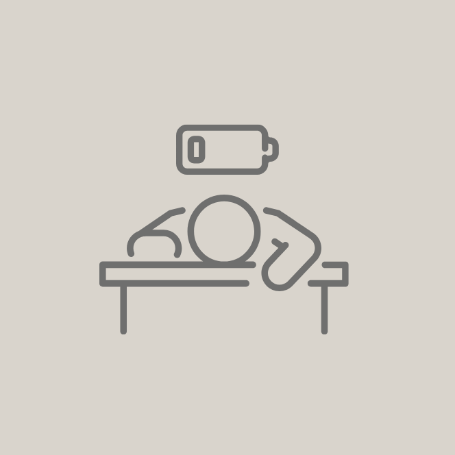 Stressed person leaning exhausted with his head on a table, battery icon above him.